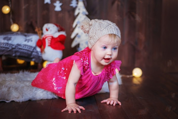 Little baby girl in the room decorated for Christmas.