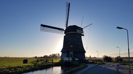 Molino de Holanada a contraluz en el campo