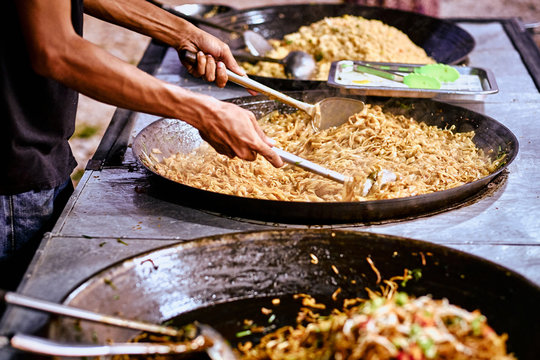 Fried noodles in a wok. Asian, Indian and Chinese street food. Food court on local market of Langkawi island, Malaysia..Traditional asian street food.