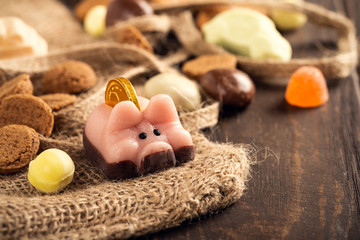 Fototapeta na wymiar Dutch holiday 'Sinterklaas' greeting card with marzipan pig and traditional sweets kruidnoten, pepernoten for the. Festive concept with copy space.
