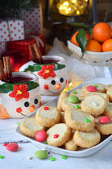 Christmas and new year holiday celebration concept background. Mug of mulled wine with spices, homemade nut cookie, shortbread, xmas tree decoration on wooden table