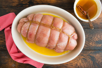 Raw stuffed turkey breast fillet and sauce for baking with honey, orange juice and cinnamon. Wooden rustic table, top view