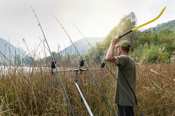 Fishing adventures. Angler with a throwing stick for boilies  