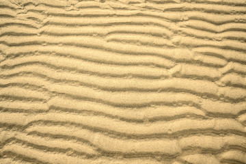 natural pattern rippled yellow sand on the beach or in the desert, background, texture