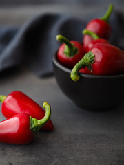 Chilli peppers in black bowl on dark table. Close up.