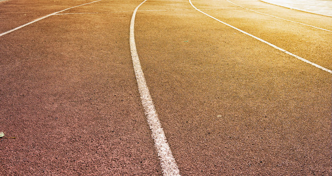 Running track at the stadium in the light of the sun's rays
