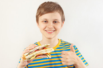 Little funny boy recommends and likes double sandwich on a white background
