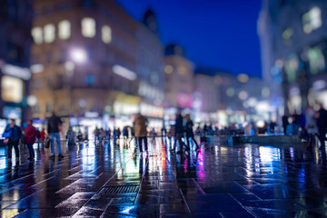 crowd of people walking on the night rainy streets in the city 