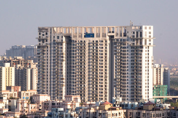 Fototapeta na wymiar Aerial shot of skyscraper, houses, buildings in noida, gurgaon, delhi, bangalore, hyderabad, jaipur, lucknow. The growing cities housing offices are all moving higher up