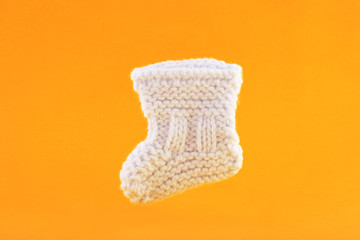 White baby sock on orange background