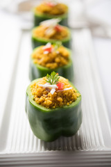 Stuffed capsicum or bharwa shimla mirchi is a popular Indian main course recipe. Served in a plate over moody background. Selective focus