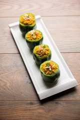 Stuffed capsicum or bharwa shimla mirchi is a popular Indian main course recipe. Served in a plate over moody background. Selective focus