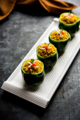 Stuffed capsicum or bharwa shimla mirchi is a popular Indian main course recipe. Served in a plate over moody background. Selective focus