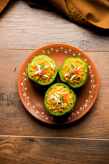 Stuffed capsicum or bharwa shimla mirchi is a popular Indian main course recipe. Served in a plate over moody background. Selective focus
