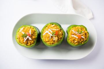 Stuffed capsicum or bharwa shimla mirchi is a popular Indian main course recipe. Served in a plate over moody background. Selective focus