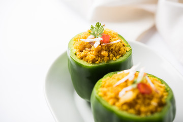 Stuffed capsicum or bharwa shimla mirchi is a popular Indian main course recipe. Served in a plate over moody background. Selective focus