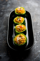 Stuffed capsicum or bharwa shimla mirchi is a popular Indian main course recipe. Served in a plate over moody background. Selective focus