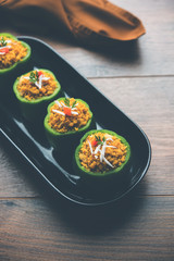 Stuffed capsicum or bharwa shimla mirchi is a popular Indian main course recipe. Served in a plate over moody background. Selective focus