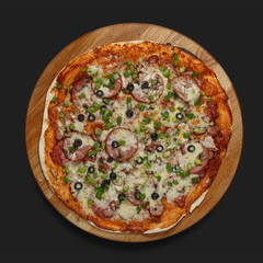 Appetizing pizza on a wooden board on a dark background. Classic feed.