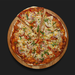 Appetizing pizza on a wooden board on a dark background. Classic feed.