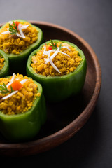 Stuffed capsicum or bharwa shimla mirchi is a popular Indian main course recipe. Served in a plate over moody background. Selective focus