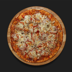Appetizing pizza on a wooden board on a dark background. Classic feed.