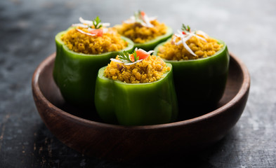 Stuffed capsicum or bharwa shimla mirchi is a popular Indian main course recipe. Served in a plate over moody background. Selective focus