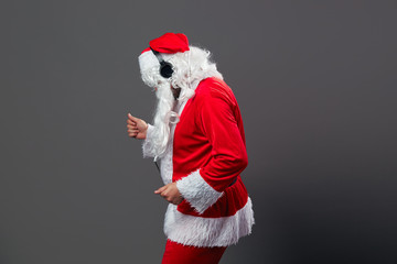 Santa Claus with a long white beard in headphones stands is dancing on the white background.