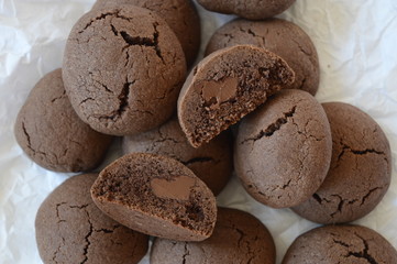 Closeup homemade crisp, cracked cocoa cookies with liquid chocolate with blurred background
