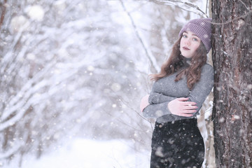 Fototapeta na wymiar Girl in a winter park in snowfall