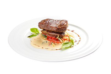 Veal medallion with vegetables. On a white background