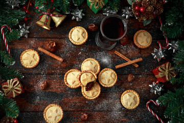 Fototapeta na wymiar British Christmas mince pies with decoration, gifts, green tree branch on wooden rustic table