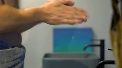 Young man washing his hands in bathroom sink