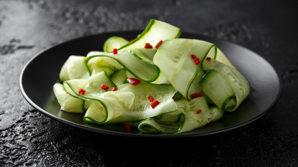 Salad of cucumber slices with salt, pepper and red pepper