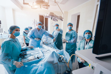 Process of gynecological surgery operation using laparoscopic equipment. Group of surgeons in...