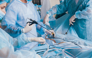 Process of gynecological surgery operation using laparoscopic equipment. Group of surgeons in operating room with surgery equipment