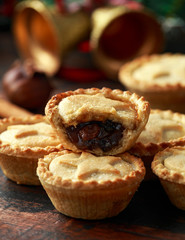 British Christmas mince pies with decoration, gifts, green tree branch on wooden rustic table