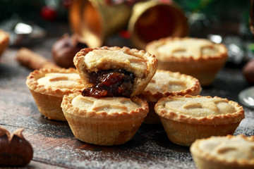 British Christmas mince pies with decoration, gifts, green tree branch on wooden rustic table