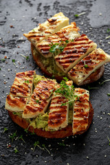 Avocado and grilled haloumi cheese toast with nigella and sesame seeds. healthy breakfast