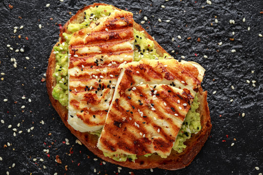 Avocado and grilled haloumi cheese toast with nigella and sesame seeds. healthy breakfast
