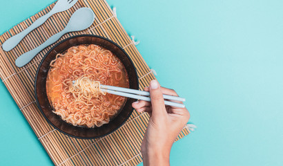 Instant noodles in boiled black bowl.