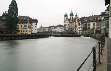 Fototapeta premium Lucerne, LU / Switzerland - November 9, 2018: the famous Swiss city of Lucerne cityscape skyline and Jesuit church with the river Reuss panorama view long exposure