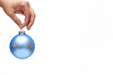 Christmas decoration blue ball with female hand over white background 