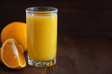 Glass of Fresh Orange Juice on dark wooden table. With Copy Space