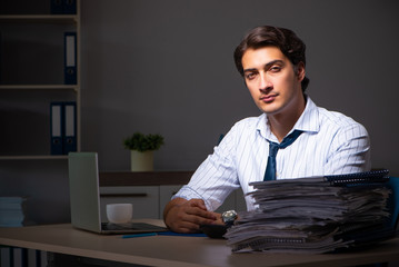 Fototapeta premium Young financial manager working late at night in office 