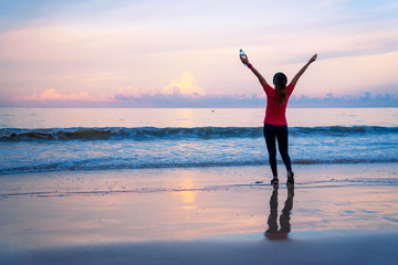 Girl running workout jogging on the beach in the morning. relax and happy with running on the sea. in summer