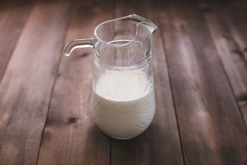 Milk in a glass jar on a dark wooden table
