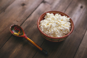 A plate of cottage cheese and a wooden spoon. Russian cuisine