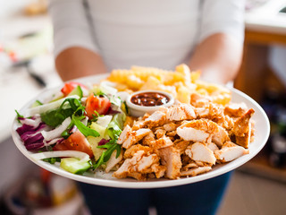 Kebab - grilled meat with french fries and vegetables on wooden background