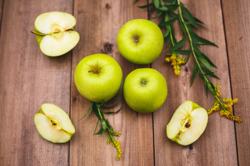 Ripe juicy apples of green color on a wooden table